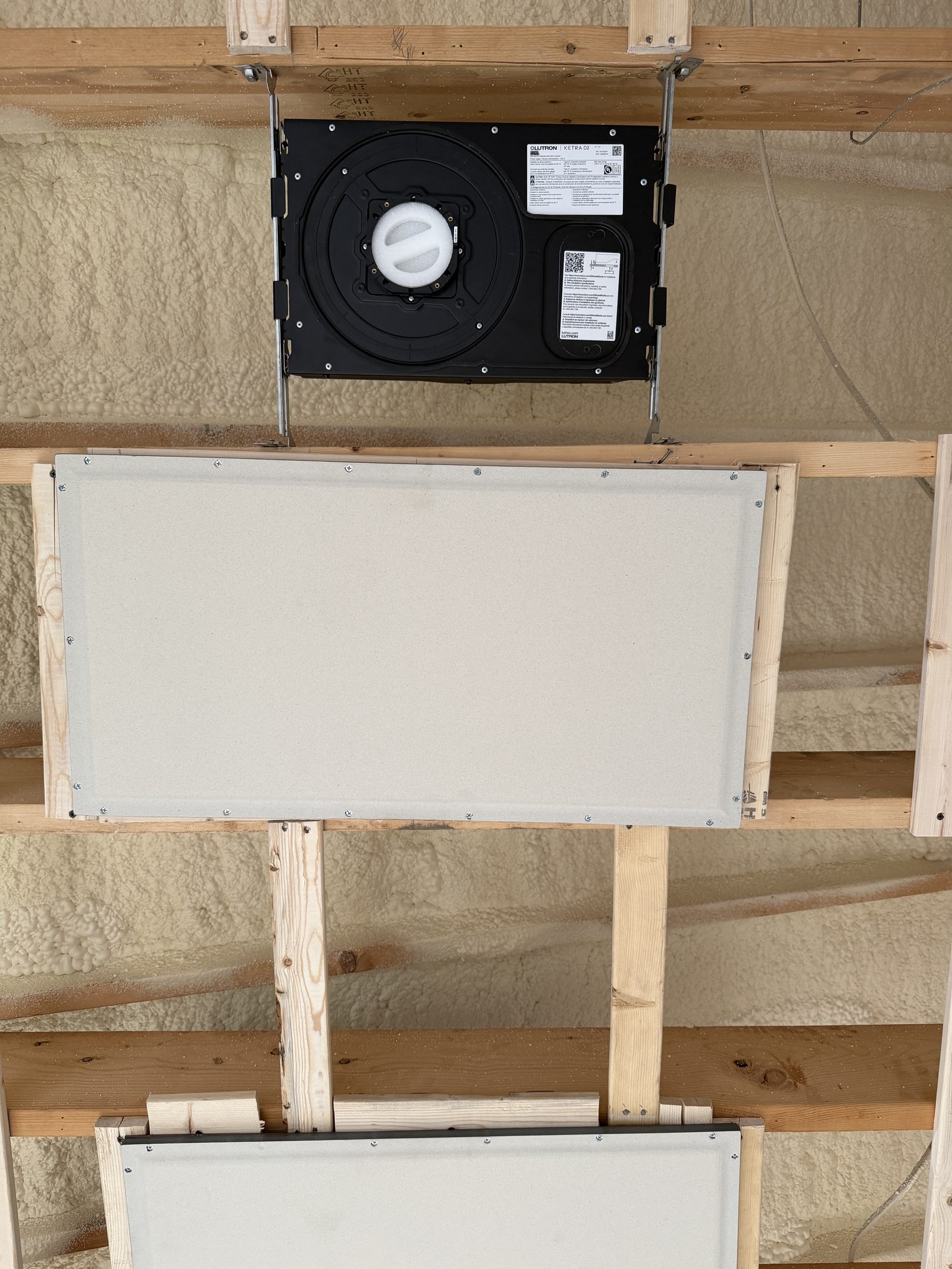 Invisible Stealth speaker — plain white flat panel set flush in the ceiling bay, with a Ketra D2 housing above for contrast