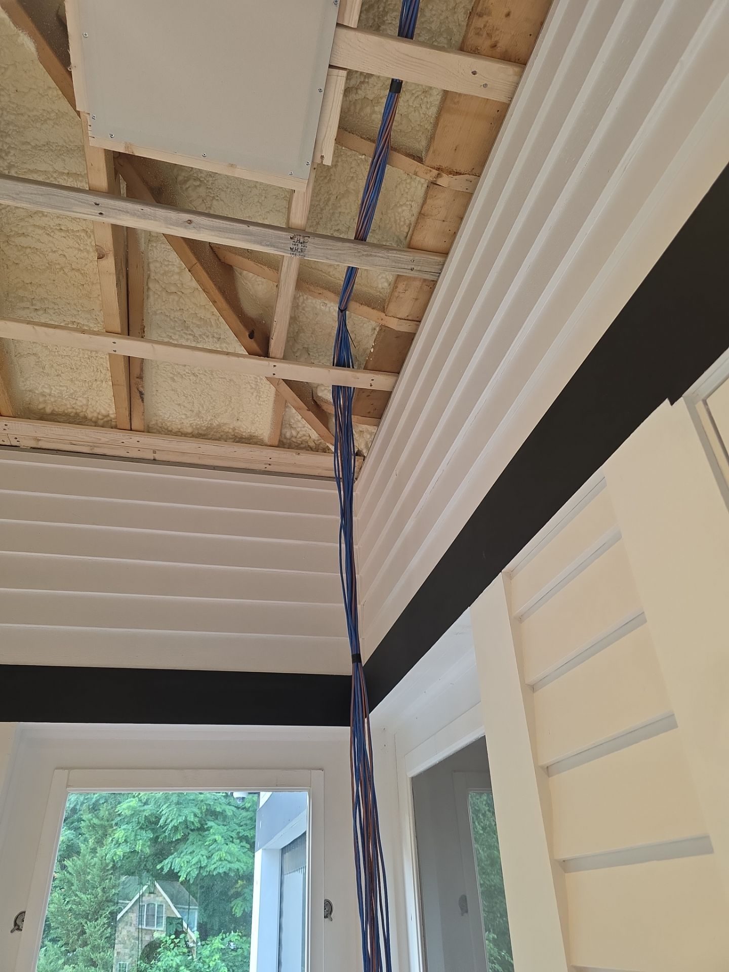 Bundle of orange Lutron QS/M wires hanging in the corner for the LS0 cove lighting